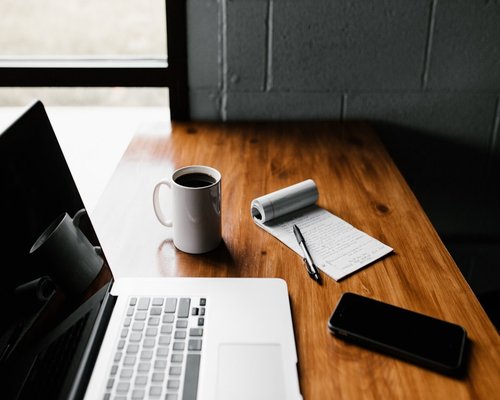 phone notebook and water on a work desk